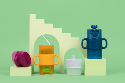 Flipping Holder KiddyTrek 4-in-1 nursing and feeding set with raspberry food pouch, juice box holder, snack cup, and sip cup.
