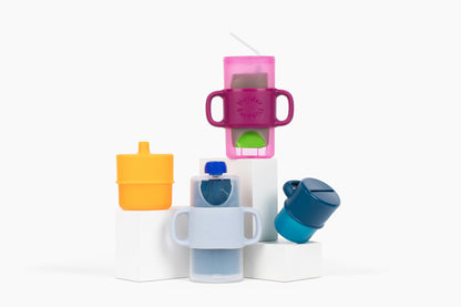 Flipping Holder KiddyTrek 4-in-1 nursing and feeding set with raspberry food pouch, juice box holder, snack cup, and sip cup.