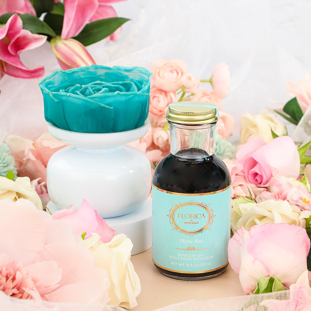 Spongellé Mystic Rose Floret Diffuser with glass bottle and floral design, releasing home fragrance with pink and white rose accents.