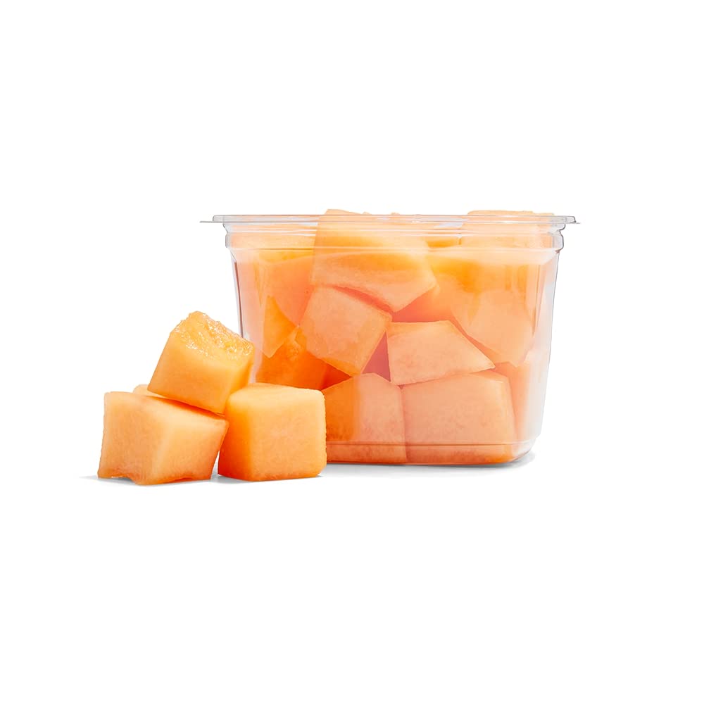 Small chunks of fresh cantaloupe melon, showcasing bright orange flesh in a clear container.