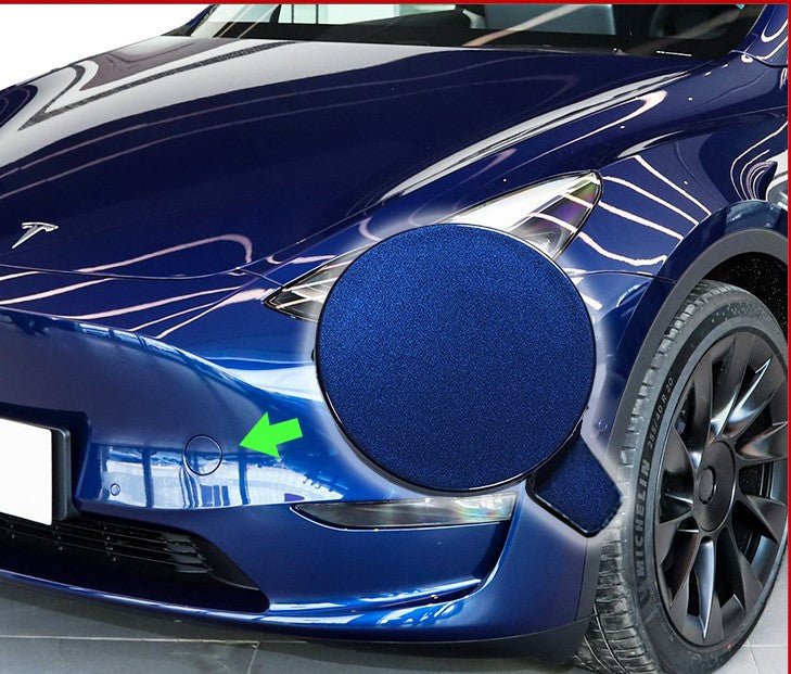 Tesla Model Y 2020-2024 OEM front bumper tow hook cover, exterior trim part, black plastic with textured finish.