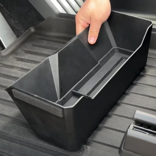 Front under-seat storage box for Tesla Cybertruck, black plastic organizer with compartments for added vehicle storage.