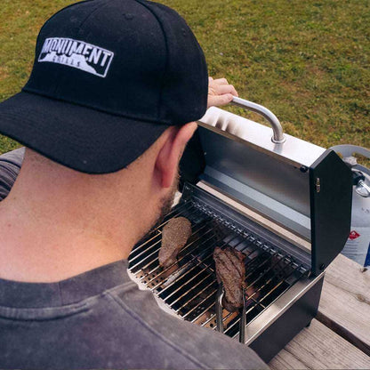 Stainless steel G22 Monument Grills tabletop propane gas grill with compact design and cooking grates.