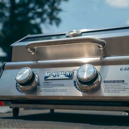 Stainless G22 tabletop propane gas grill by Monument Grills with cooking grates and control knobs.