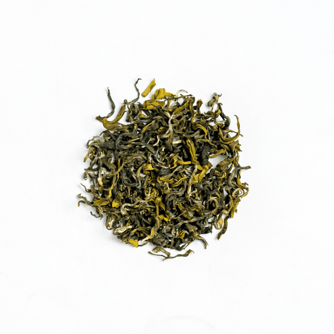 Organic Ganesha Green Tea from Nepal Tea, fresh green tea leaves in a traditional tea setup, highlighting natural and organic qualities.