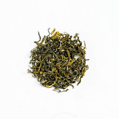 Organic Ganesha Green Tea from Nepal Tea, fresh green tea leaves in a traditional tea setup, highlighting natural and organic qualities.