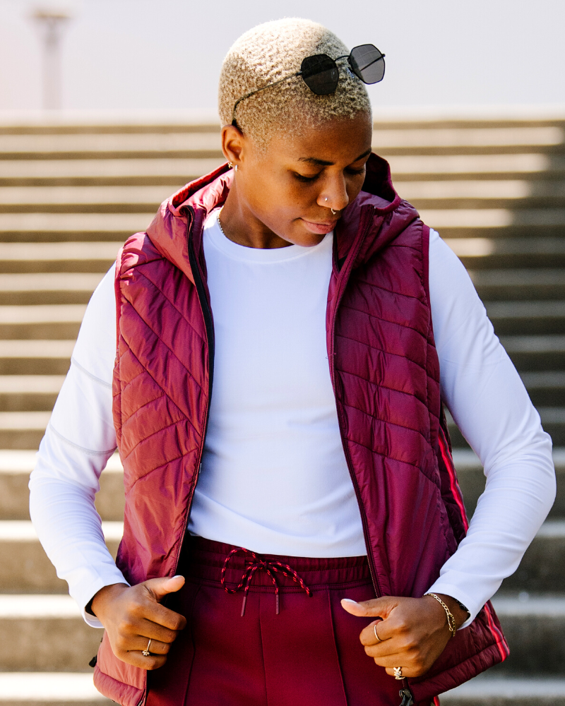 Goal Five Powerstripe eco-friendly down hooded vest in black, lifestyle image showing front view and hood detail.