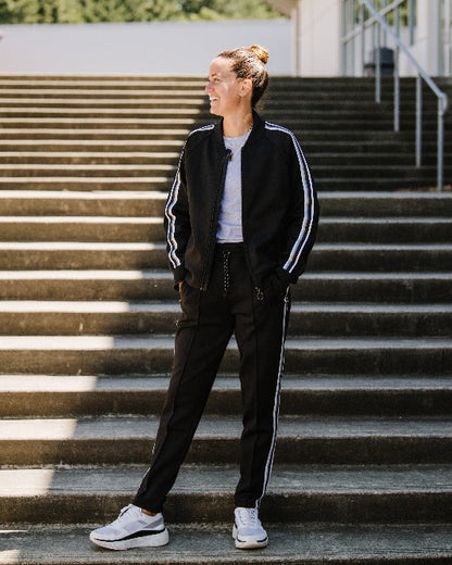 Black Goal Five Powerstripe LS Track Jacket worn as a lifestyle outfit, featuring a sleek design and athletic fit.