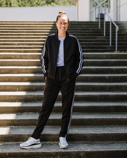 Black Goal Five Powerstripe mid-rise 28-inch 7/8 length track pant for lifestyle wear, showcasing sporty style and comfortable fit.