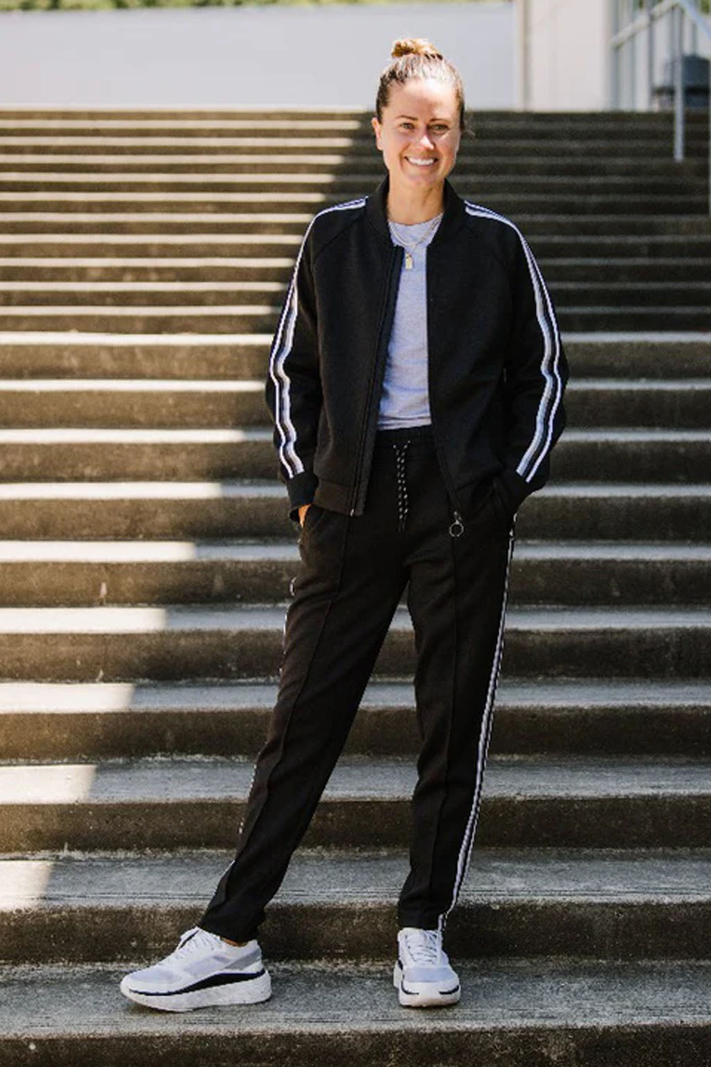 Black Goal Five Powerstripe mid-rise 28-inch 7/8 length track pants, lifestyle style, shown on a model.
