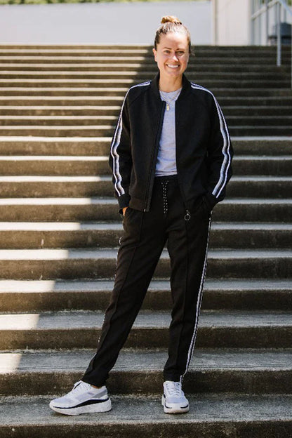 Black Goal Five Powerstripe mid-rise 28-inch 7/8 length track pants, lifestyle style, shown on a model.