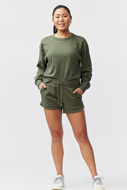 Goal Five Freasy Short in dark moss color, lifestyle image showing lightweight, comfortable fitness shorts for men.
