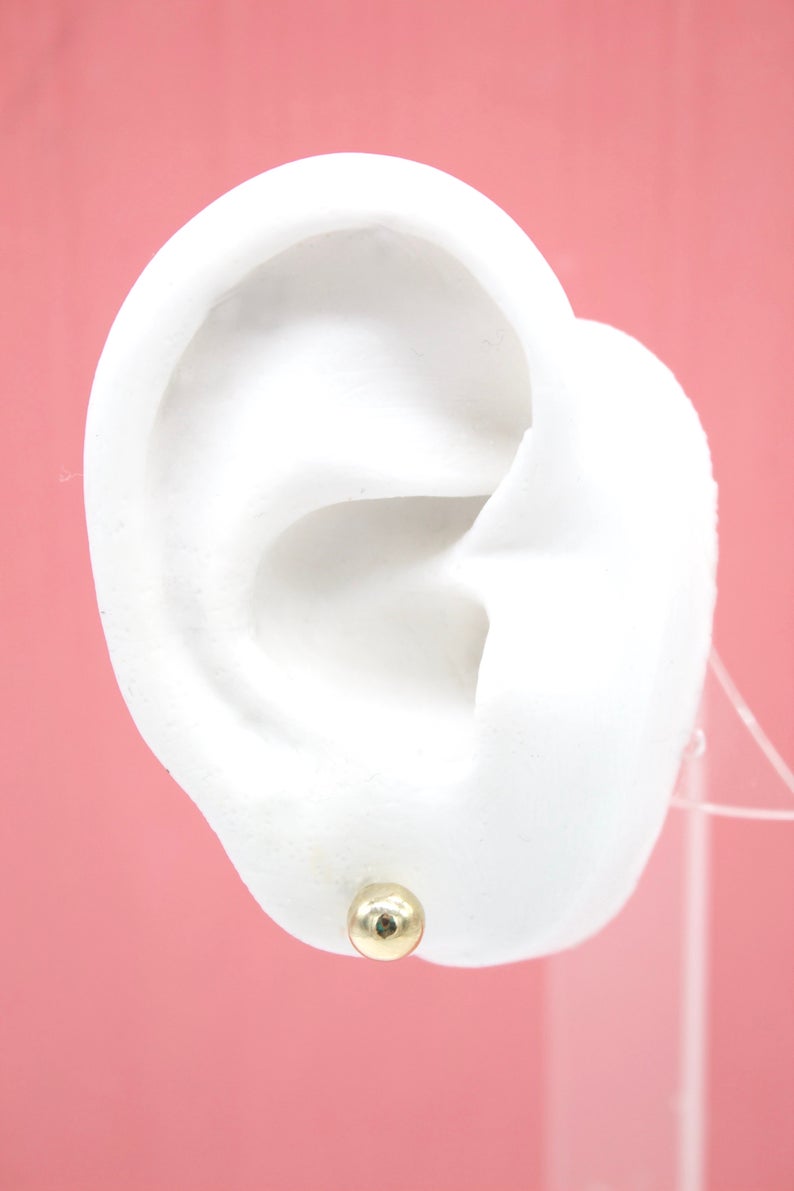 Small 18K gold-filled ball stud earrings by MIA Jewelry, featuring a minimalist design and shiny gold finish.