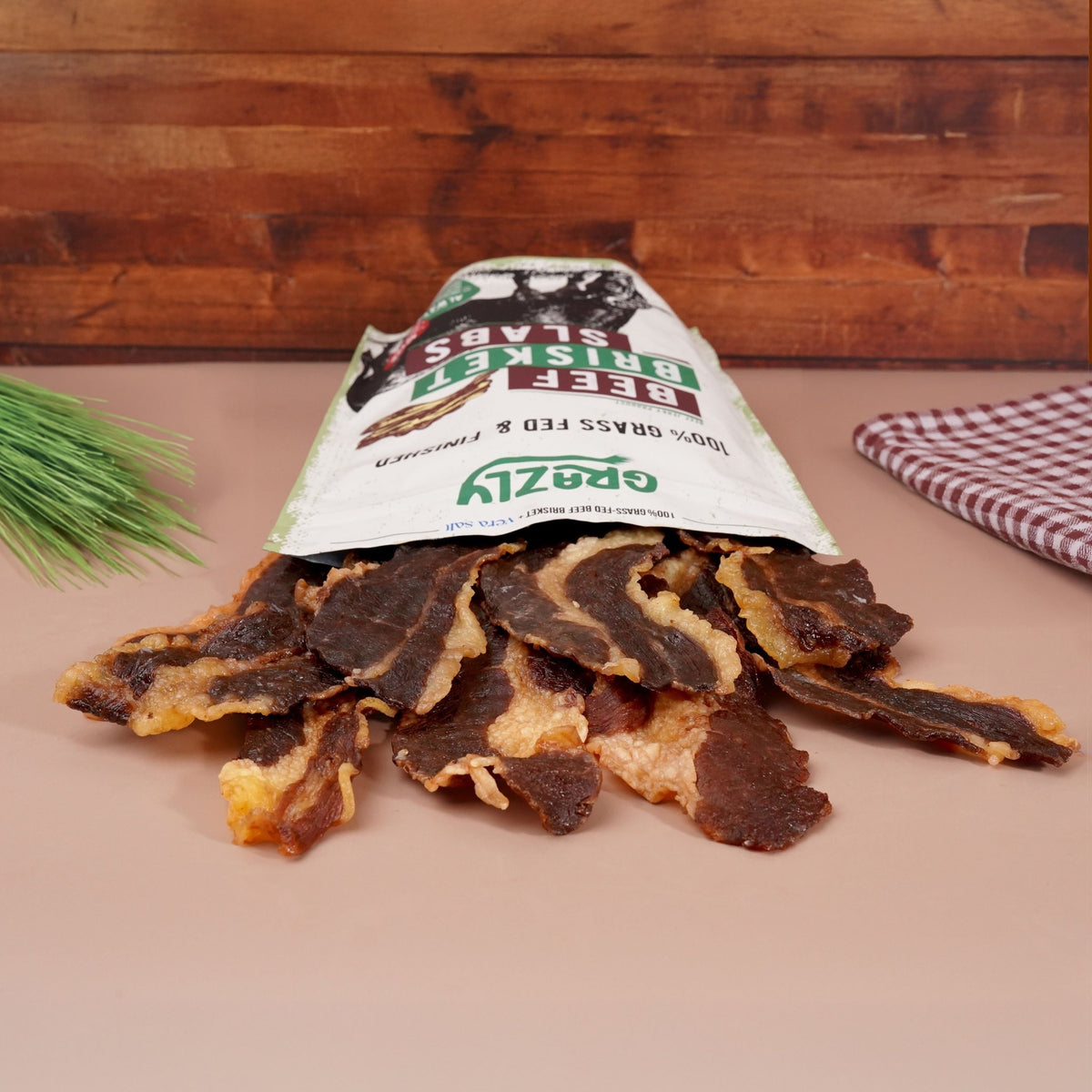 Grazly beef brisket slabs, 100% grass-fed and finished, shown as large raw meat pieces on a butcher's table