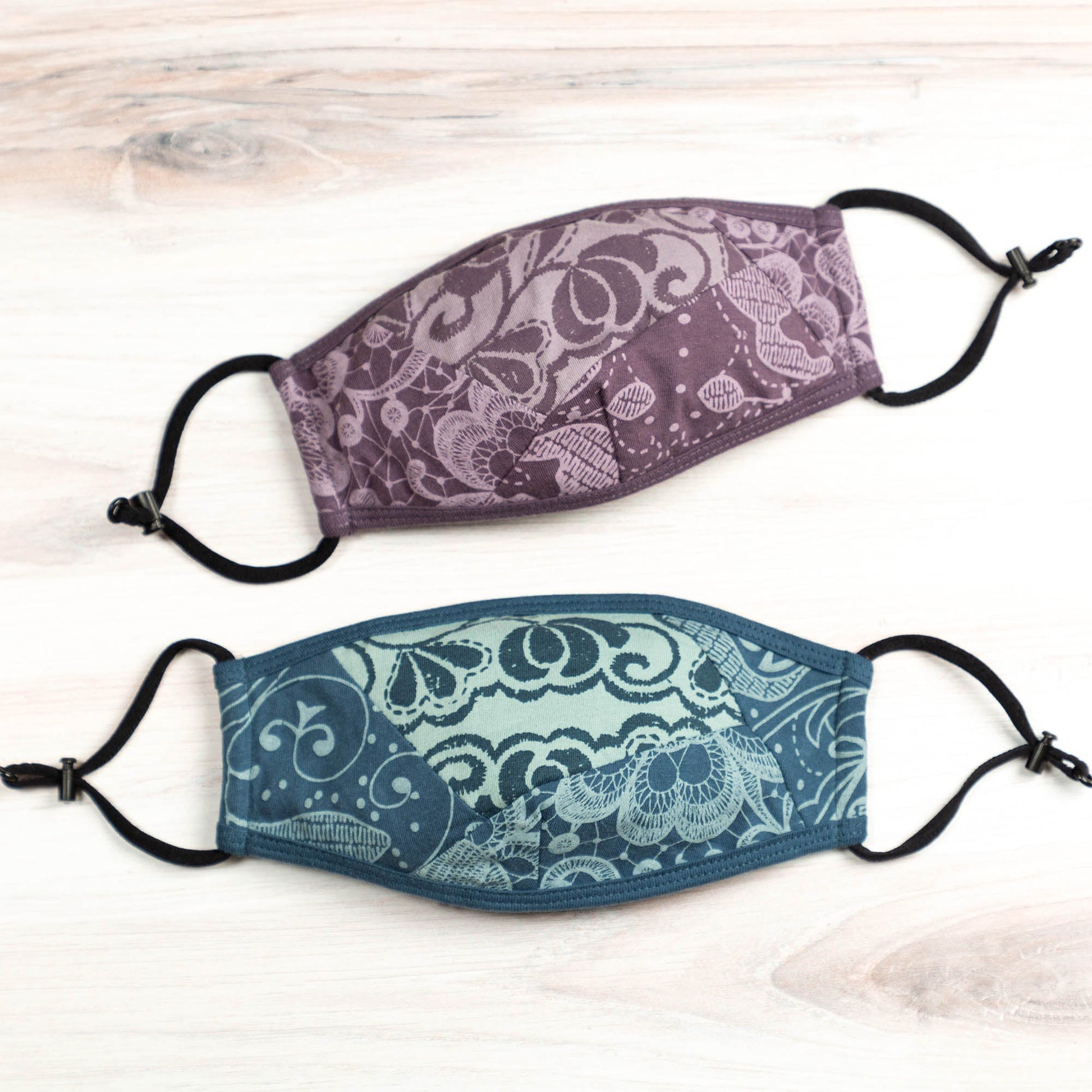 Blue organic reversible face mask by GreaterGood with patched-together design, made for comfortable face covering and protection.