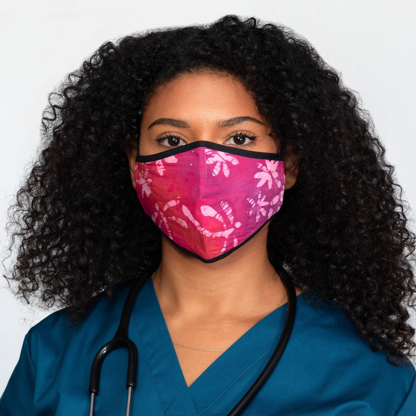Batik Delight face mask by GreaterGood featuring a colorful dragonfly pattern on fabric, designed for comfortable wear.