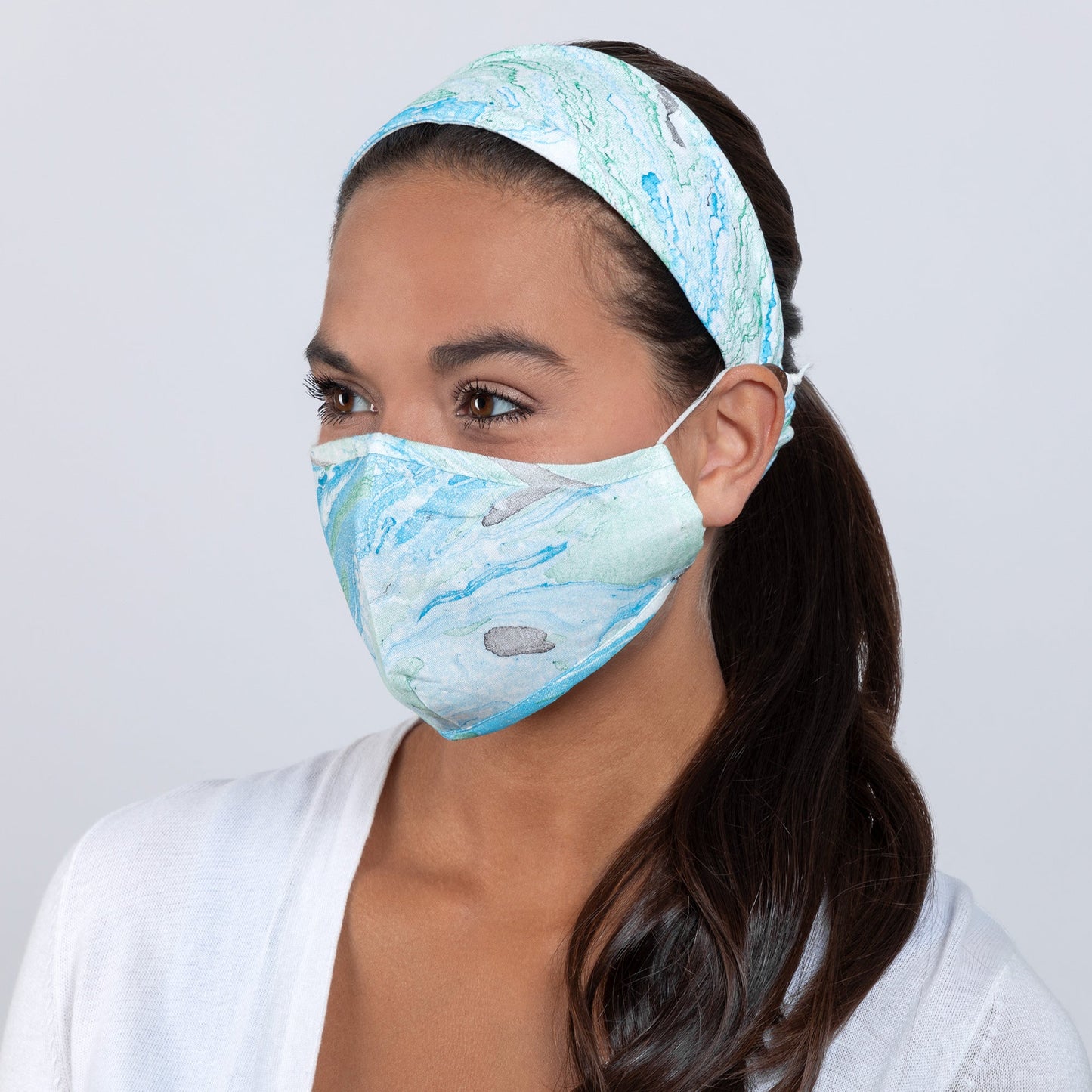 Green and blue marble-colored face mask with matching headband from GreaterGood, made of soft fabric for comfortable wear.