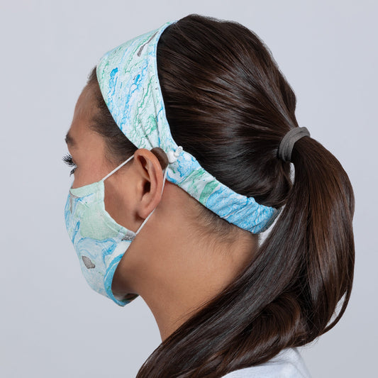 Green and blue marble-patterned face mask and matching headband from GreaterGood, made of soft fabric for comfortable wear.