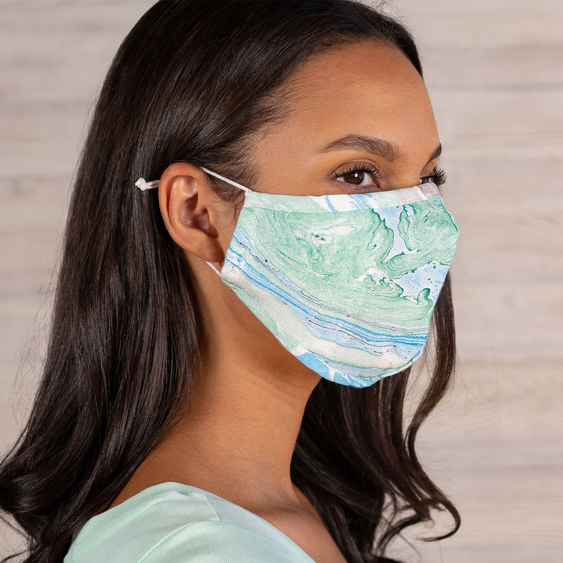 Green and blue marble-colored face mask with matching headband by GreaterGood, made of soft fabric for comfortable wear.