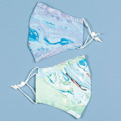 Green and blue marbleized face mask with matching headband from GreaterGood, made of soft, breathable fabric for comfortable wear.