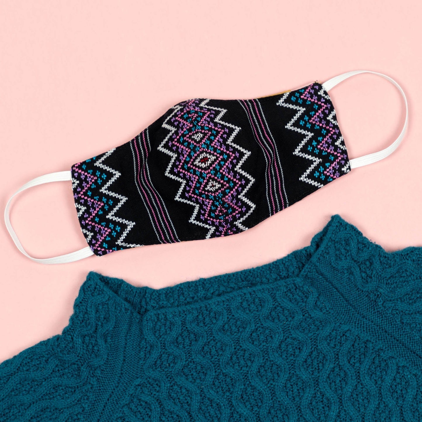 Handwoven face mask from GreaterGood, made of soft fabric with adjustable ear loops and intricate woven design.