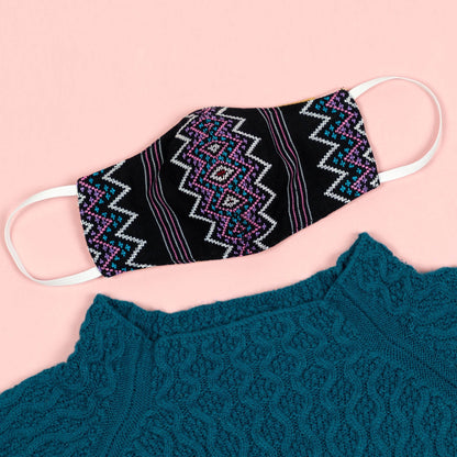 Handwoven face mask from GreaterGood, made of soft fabric with adjustable ear loops and intricate woven design.