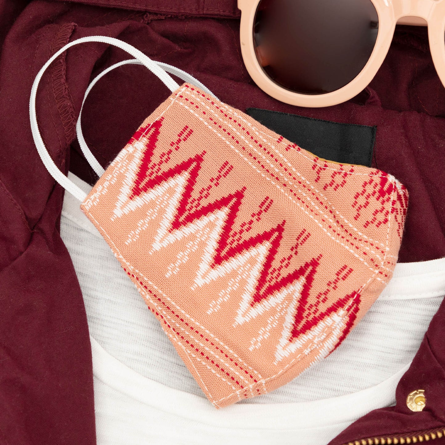 Handwoven GreaterGood face mask with intricate patterns, made of soft fabric, designed for comfort and style.