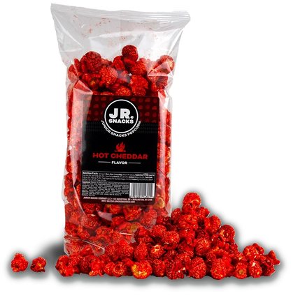 Hot cheddar Junior Snacks from Junior Snacks Company in a bag with a pile of snacks on a white background.