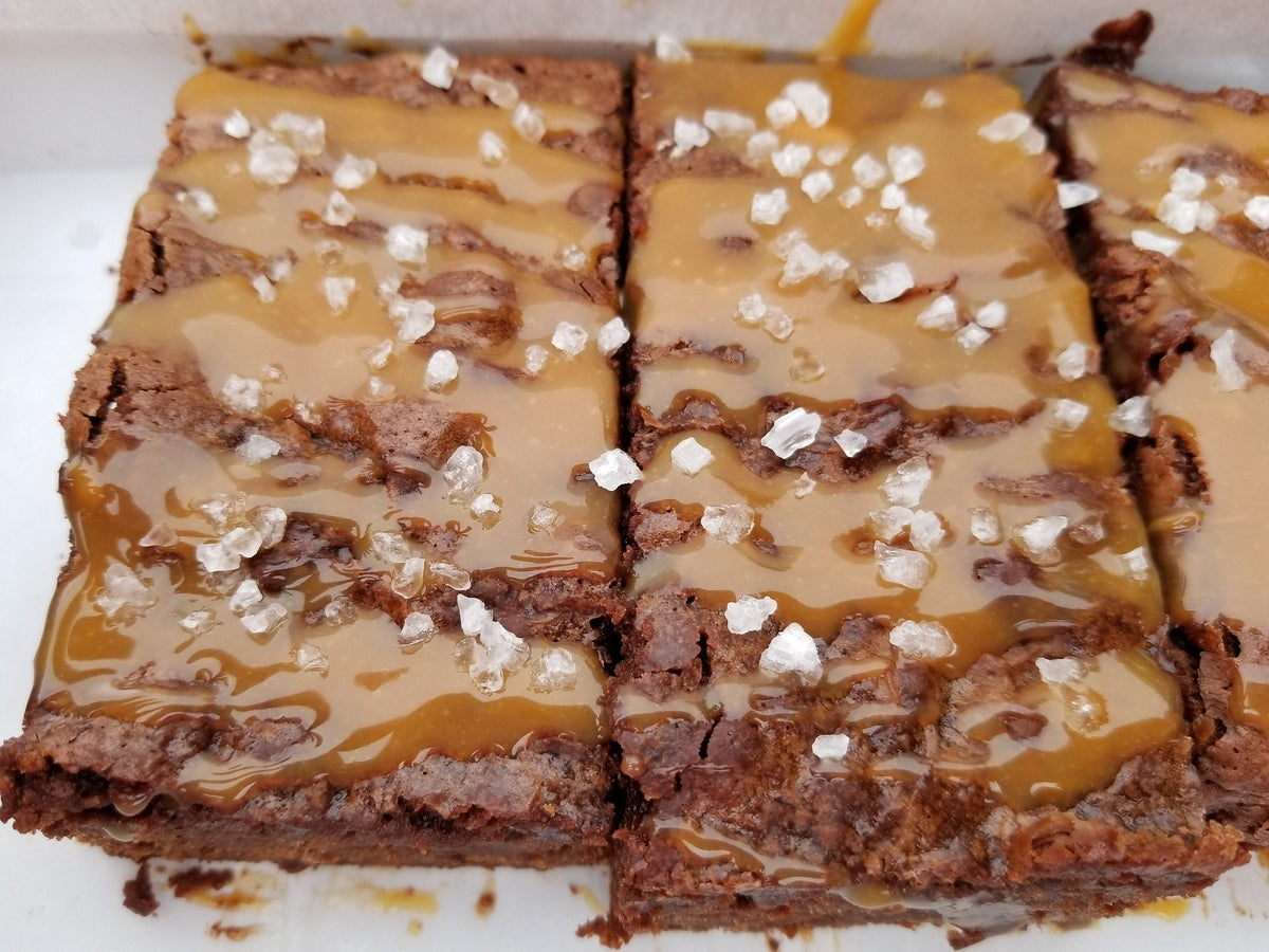 Salted caramel brownies from Let's Get Baked Artisan Desserts, showcasing rich, gooey dessert bars with caramel drizzle and a fudgy texture.
