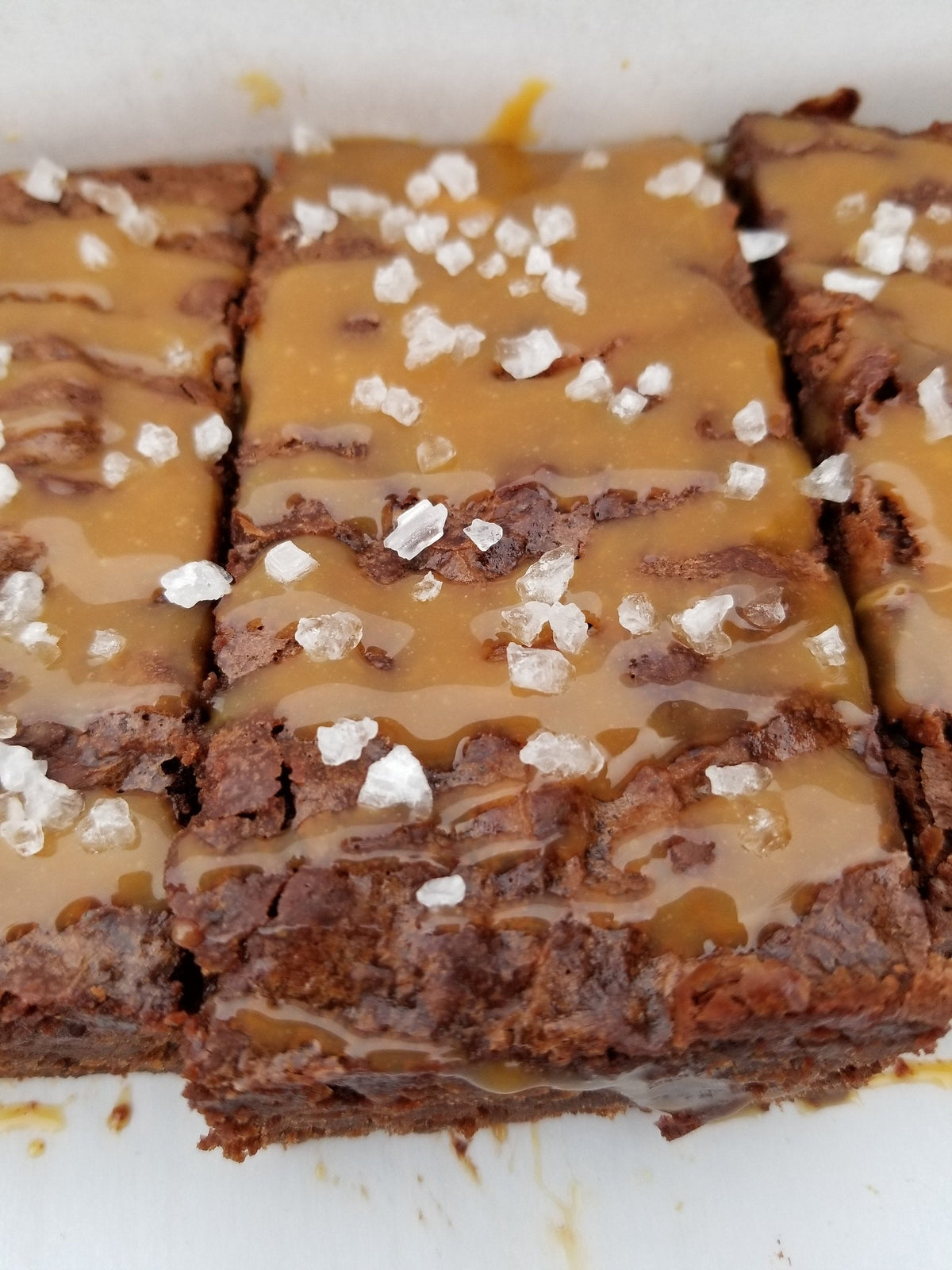 Salted caramel brownies from Let's Get Baked Artisan Desserts, showcasing rich chocolate and salted caramel topping on a dessert bar.