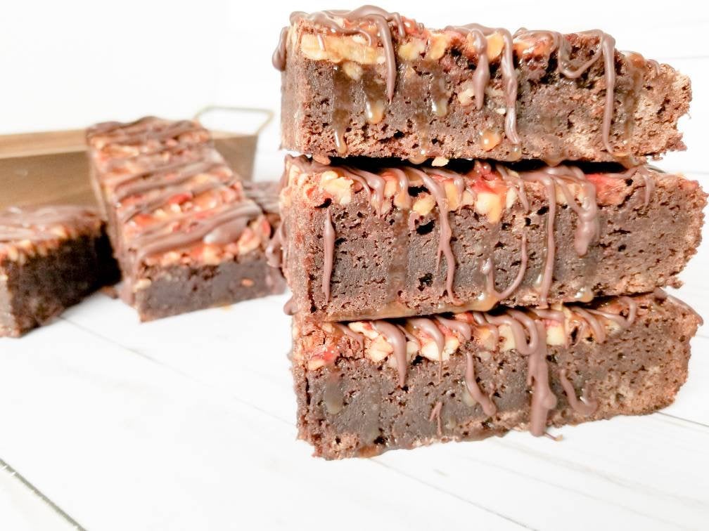 Chocolate turtle brownies from Let's Get Baked Artisan Desserts, featuring rich chocolate, caramel, and pecans in a decadent cake bar.