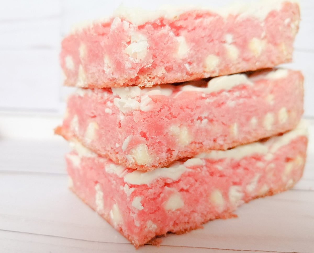 Strawberry blondies from Let's Get Baked Artisan Desserts, featuring a golden cake bar with strawberry swirls and a sweet glaze.
