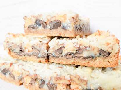 Let's Get Baked Artisan Desserts Magic Bars with layered chocolate, caramel, and graham cracker crust in a close-up image