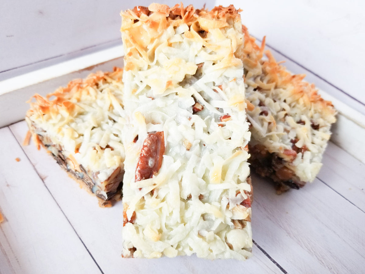 Delicious Magic Bars from Let's Get Baked Artisan Desserts, showcasing layered cake and dessert bar treats with chocolate and caramel.
