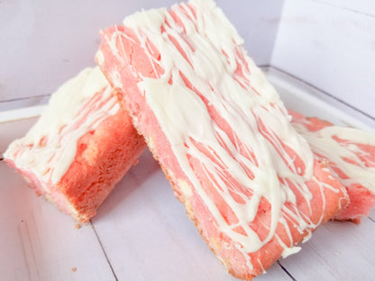 Strawberry blondies from Let's Get Baked Artisan Desserts, featuring golden cake bars with strawberry swirls and a moist texture.