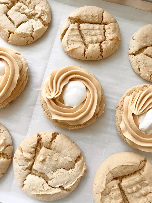 Let's Get Baked Artisan Desserts FlufferNutter Sammies cookies with peanut butter and marshmallow filling, displayed on a plate.