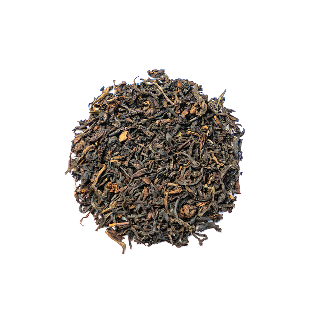 Organic Himalayan Sunrise Kanchanjangha Noir tea leaves from Nepal Tea, showcasing dark, rolled tea leaves in a natural setting.