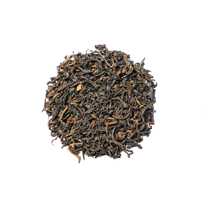 Organic Himalayan Sunrise Kanchanjangha Noir tea leaves from Nepal Tea, showcasing dark, rolled tea leaves in a natural setting.