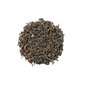 Organic Himalayan Sunrise Kanchanjangha Noir tea leaves from Nepal Tea, showcasing dark, rolled tea leaves in a natural setting.