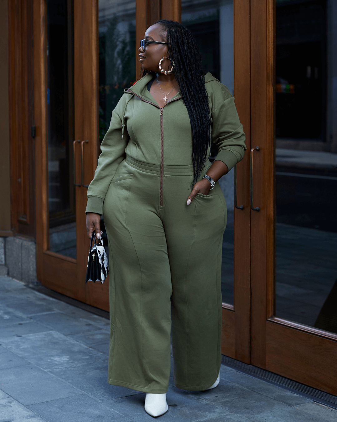 Green satin-lined jumpsuit by KINApparel, showing the full-length, tailored fit with long sleeves and a sleek, smooth fabric finish.