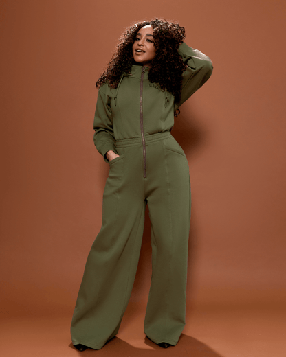 Green satin-lined jumpsuit by KINApparel, showing the full length with a fitted waist and long sleeves.