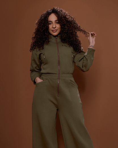 Green satin-lined jumpsuit by KINApparel, shown in XS size, featuring a sleek, smooth fabric with stylish, comfortable fit.