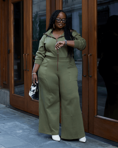 Green satin-lined jumpsuit by KINApparel, shown in XS size, with a smooth, shiny fabric and tailored fit.