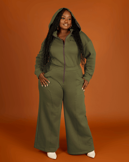 Green satin-lined jumpsuit by KINApparel, featuring a fitted design and smooth satin interior, shown on a model.