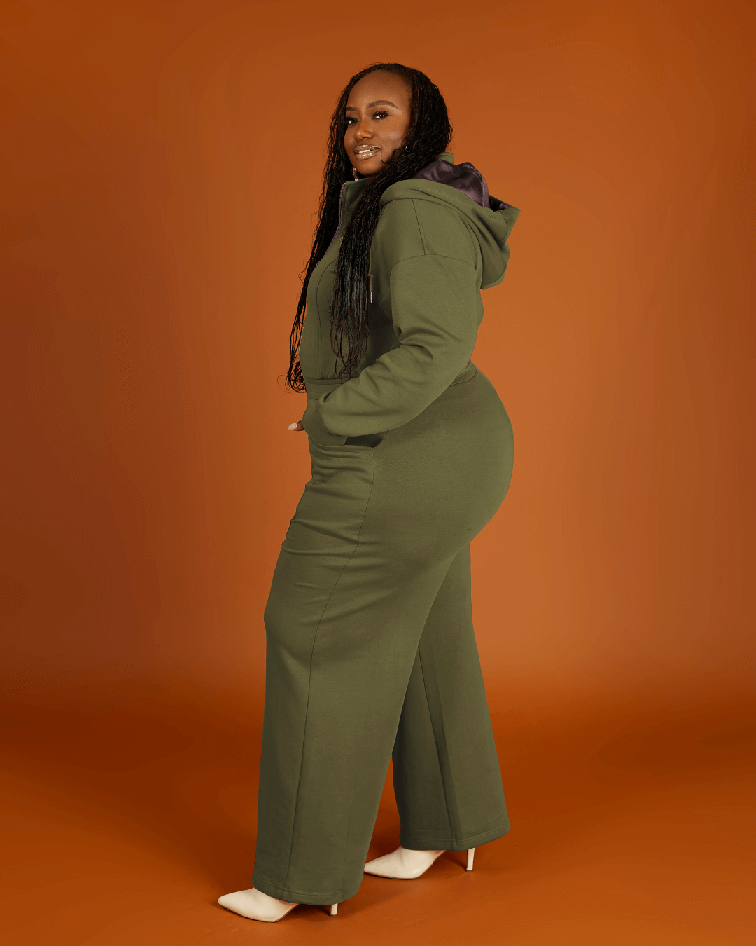 Green satin-lined jumpsuit by KINApparel featuring a fitted design and long sleeves, shown on a model.