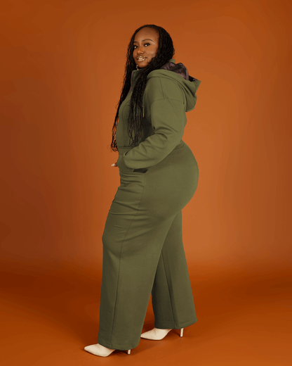 Green satin-lined jumpsuit by KINApparel featuring a fitted design and long sleeves, shown on a model.