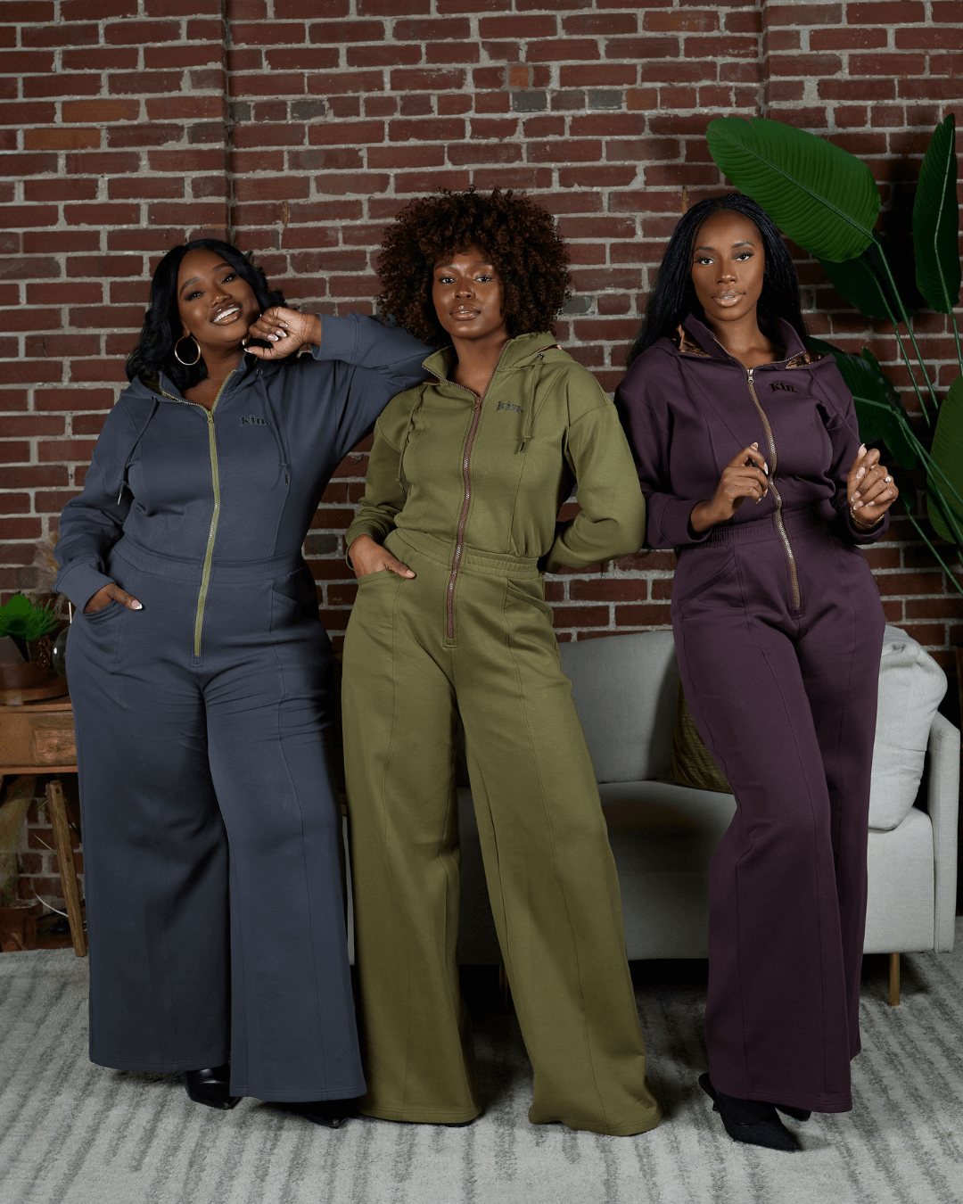 Green satin-lined jumpsuit by KINApparel featuring a fitted design and long sleeves, displayed on a neutral background.