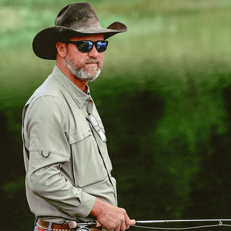 Man wearing a GameGuard Mesquite Scout long sleeve shirt, suitable for outdoor activities, with a camouflage pattern and button-up design.