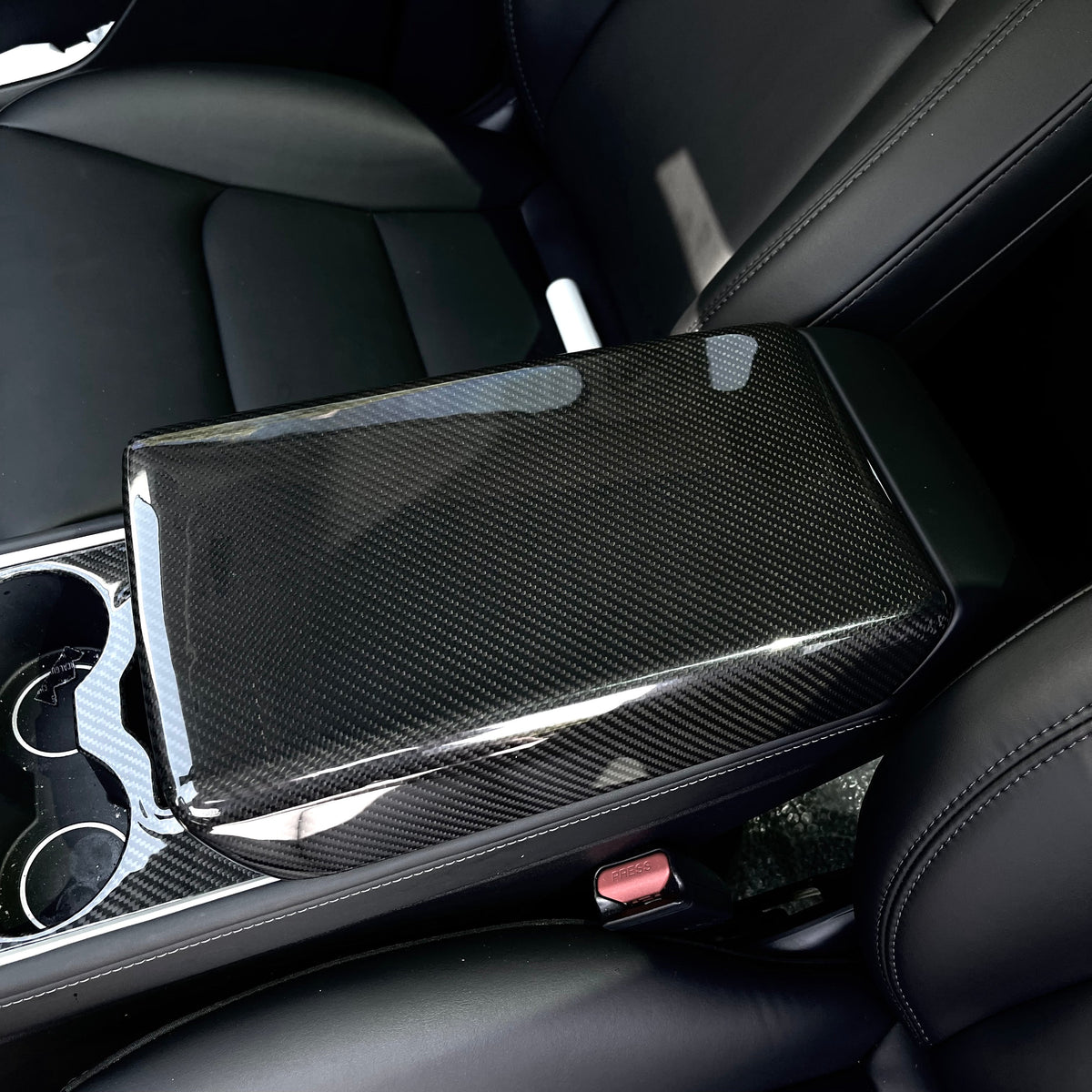Tesla Model Y armrest cover in dry carbon fiber, interior modification by TESERY with sleek, textured finish.