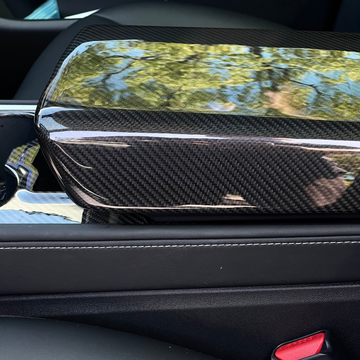 Tesla Model Y armrest cover in dry carbon fiber, custom interior mod by TESERY for a sleek, modern look.